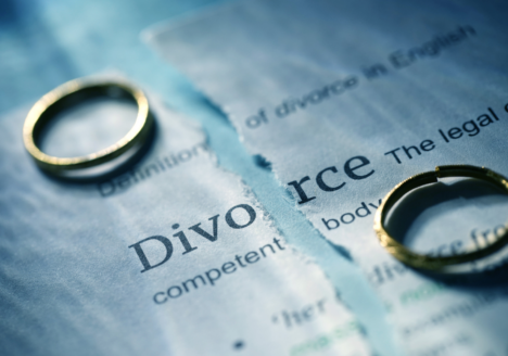 Two rings on top of a torn divorce contract symbolizing divorce